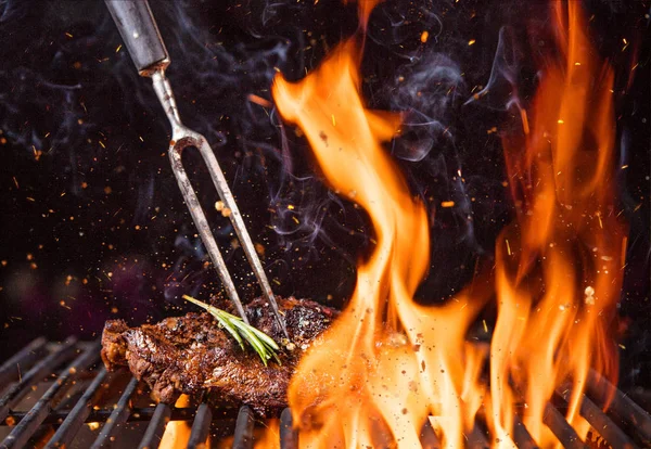 Rindersteak auf dem Grill mit Flammen — Stockfoto