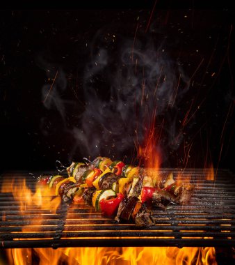 Chicken skewers on the grill with flames clipart