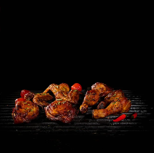 Chicken legs and wings on the grill with flames — Stock Photo, Image