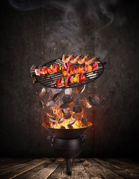Su ısıtıcısı ızgara sıcak briketler, dökme demir ızgara ve lezzetli şişleri havada uçan.