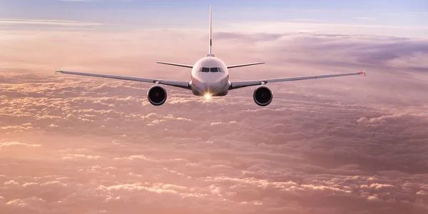 Avión comercial volando sobre nubes dramáticas . — Foto de Stock