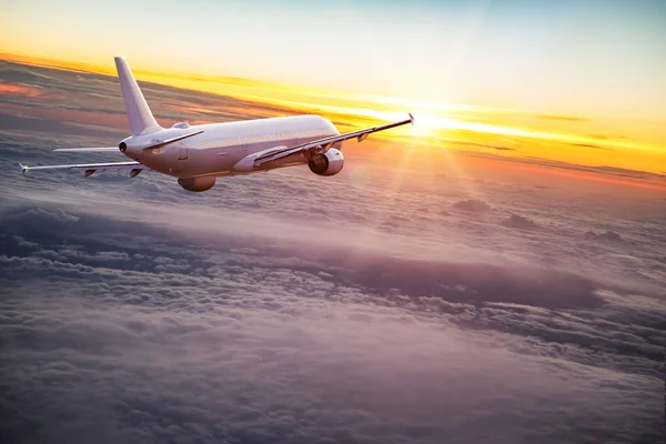 Handlowych samolot leci ponad chmury dramatyczne. — Zdjęcie stockowe