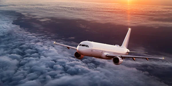 Avión comercial volando sobre nubes dramáticas . — Foto de Stock