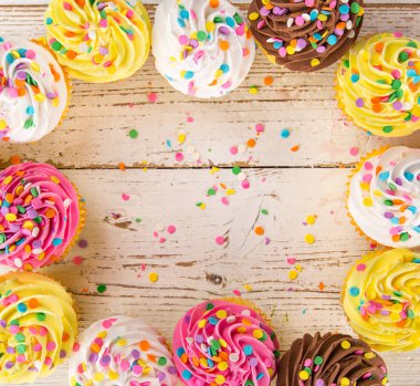 Ahşap arka plan üzerinde renkli fincan kek.