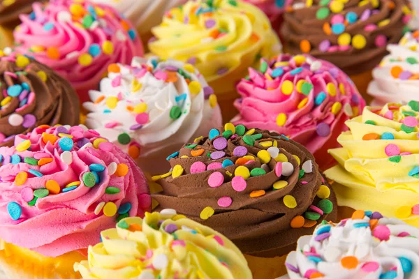 Colorful cup cakes on wooden background. — Stock Photo, Image