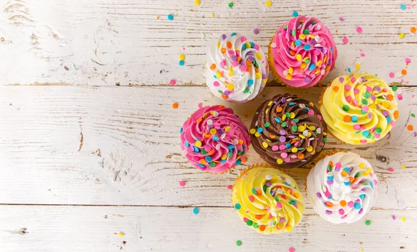 Colorful cup cakes on wooden background. — Stock Photo, Image