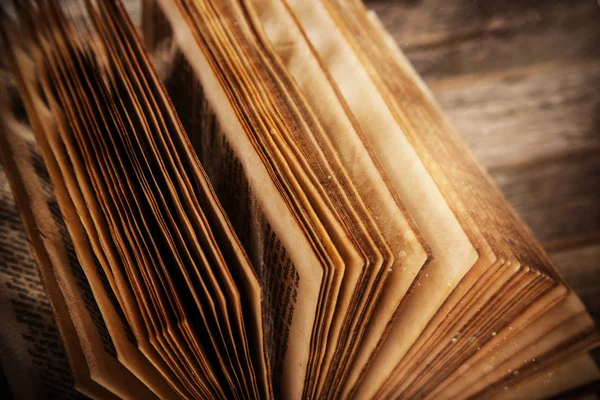 Παλιά ανοιχτό βιβλίο σε ξύλινο τραπέζι με μυστικιστικό μαγικό φωτεινό φως. — Φωτογραφία Αρχείου