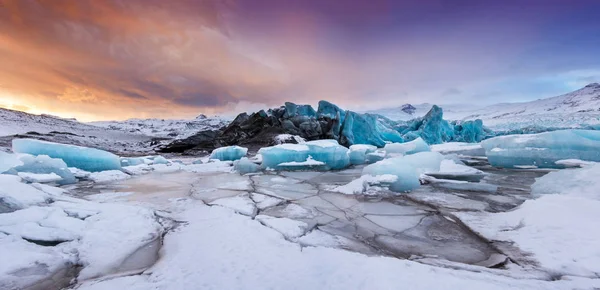 Famous Fjallsarlon glacier and lagoon with icebergs swimming on frozen water. — Stock Photo, Image