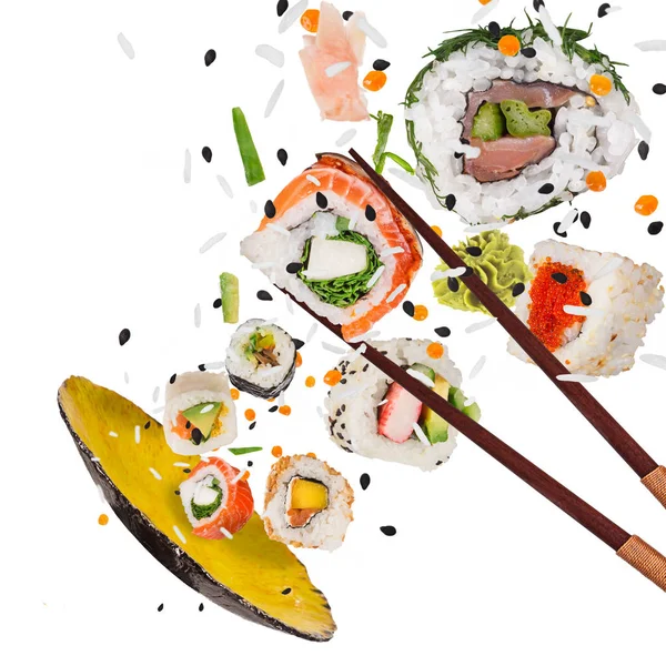 Pedaços de delicioso sushi japonês congelado no ar. — Fotografia de Stock