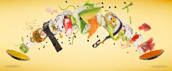 Trozos de delicioso sushi japonés congelado en el aire. — Foto de Stock