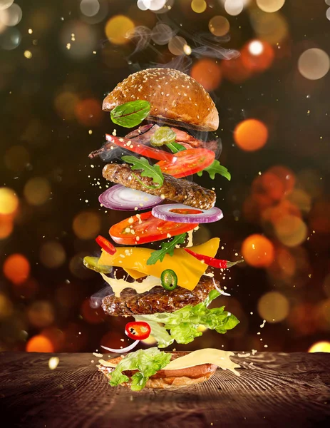 Großer leckerer Burger mit fliegenden Zutaten. — Stockfoto