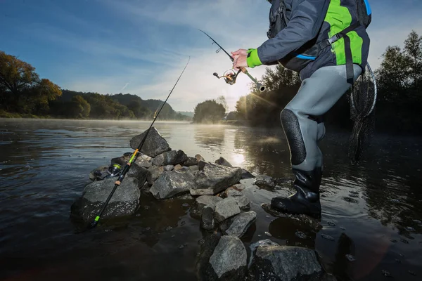 Mens vissen in de rivier met vliegen staaf tijdens Zomerochtend. — Stockfoto