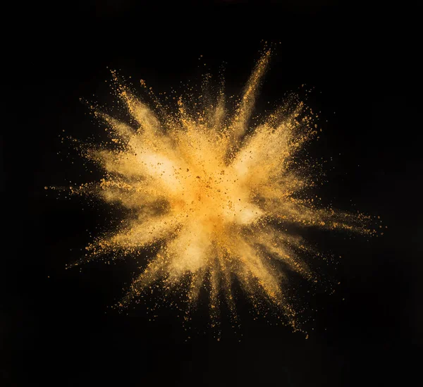 Взрыв золотого порошка на черном фоне . — стоковое фото