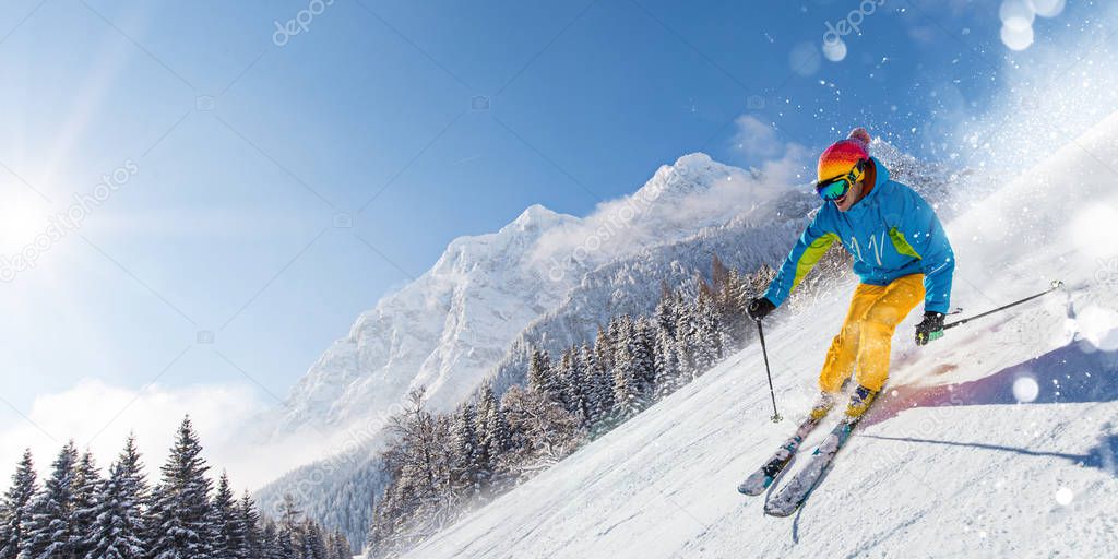 Skier skiing downhill in high mountains