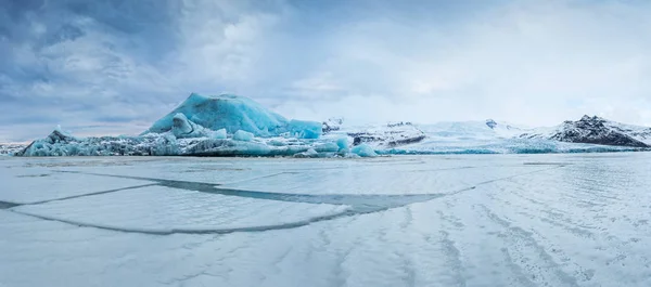 Famous Fjallsarlon glacier and lagoon with icebergs swimming on frozen water. — Stock Photo, Image