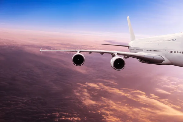 Nagy repülőgép repülő drámai felhők felett. — Stock Fotó