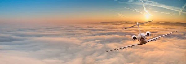 Avión jet privado volando por encima de nubes dramáticas . — Foto de Stock