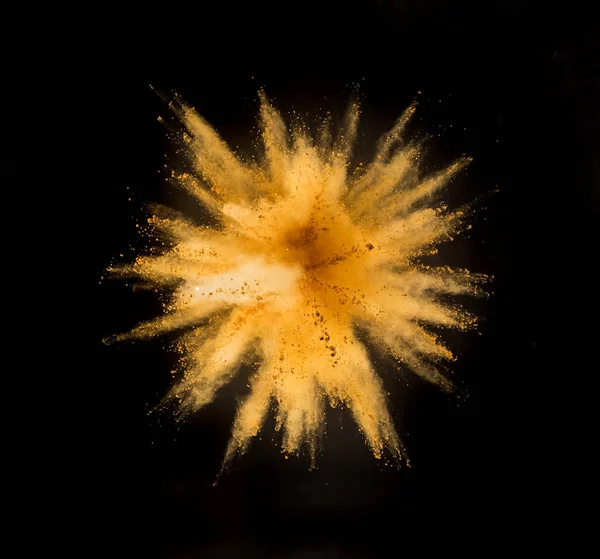 Взрыв золотого порошка на черном фоне . — стоковое фото