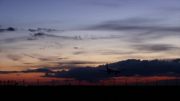 Vliegtuig landing tijdens zonsondergang. — Stockvideo