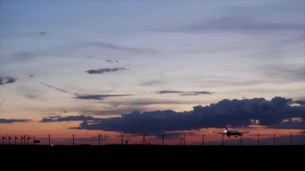 Flygplan landar under solnedgången. — Stockvideo