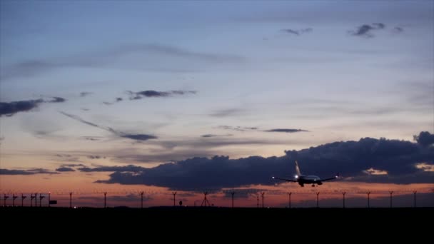 Vliegtuig landing tijdens zonsondergang. — Stockvideo