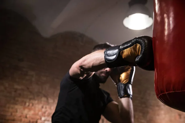 Ręka boksera w momencie wpływu na worek treningowy. — Zdjęcie stockowe