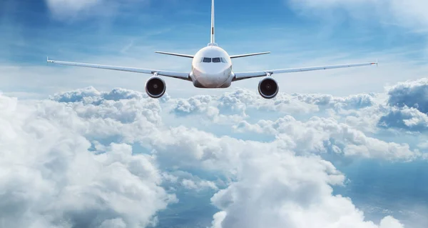 Avião comercial jetliner voando acima de nuvens dramáticas. — Fotografia de Stock