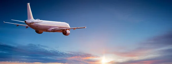 Avión comercial jetliner volando por encima de nubes dramáticas. — Foto de Stock