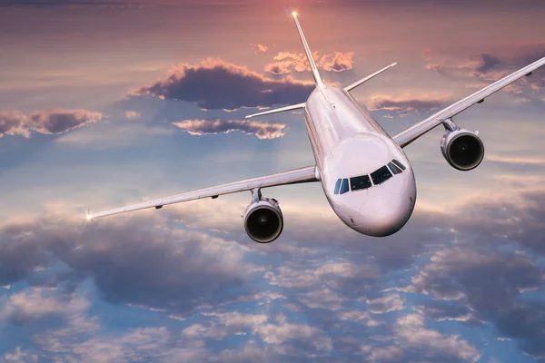 商业飞机喷气式客机在美丽的落日灯光下 在戏剧性的云彩之上飞行 旅行概念 — 图库照片