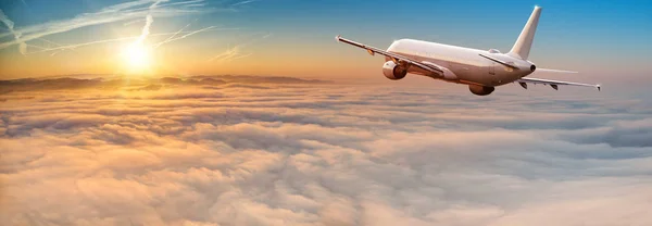 Avión comercial jetliner volando por encima de nubes dramáticas. — Foto de Stock