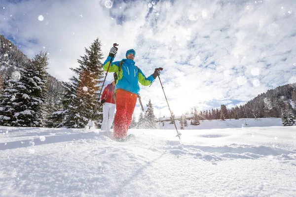 Zonnige winterlandschap met man op sneeuwschoenen. — Stockfoto