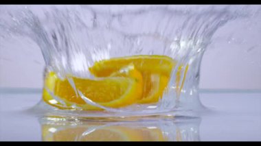 Limon dilimleri düşen suya, ağır çekim.