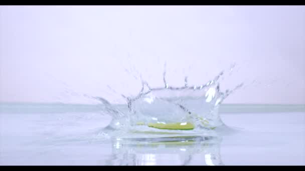 Plasterki limonki wpadnięciem do wody, zwolnionym tempie. — Wideo stockowe