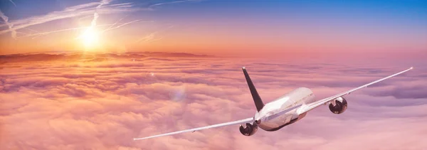 Avión comercial jetliner volando por encima de nubes dramáticas. — Foto de Stock