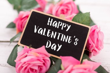 Sevgililer günü için küçük kara tahta. Arka plan ile pembe güller.