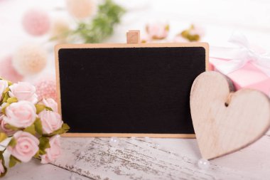 Küçük boş yazı tahtası Sevgililer için anne ya da kadın gün. Arka plan ile pembe güller.