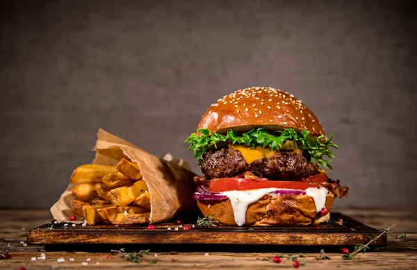 Leckerer Burger auf Holztisch. — Stockfoto