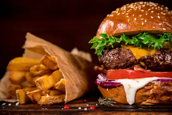 Ízletes hamburger a fa asztalon. — Stock Fotó