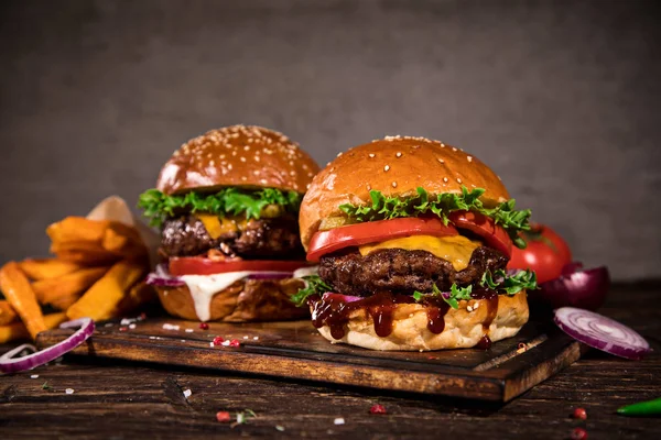 Lekkere hamburgers op houten tafel. — Stockfoto