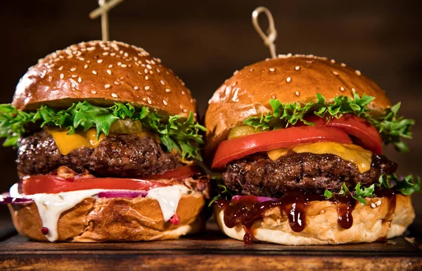 Sabrosas hamburguesas sobre mesa de madera. — Foto de Stock