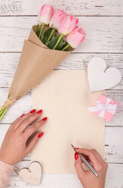 Papel en blanco vacío con manos de mujer. Fondo con rosas rosadas en jarrón . —  Fotos de Stock