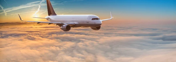 Commercial airplane jetliner flying above dramatic clouds. — Stock Photo, Image