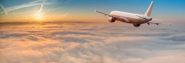 Avión comercial jetliner volando por encima de nubes dramáticas. — Foto de Stock