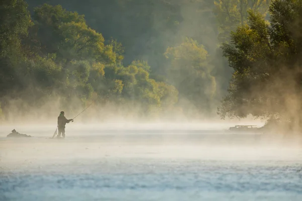 Mannen vissen in de rivier met vliegen staaf tijdens Zomerochtend. — Stockfoto