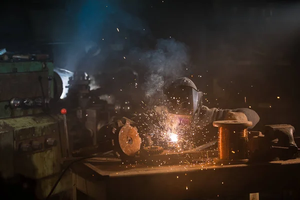 Soldador é soldar parte de metal na fábrica — Fotografia de Stock