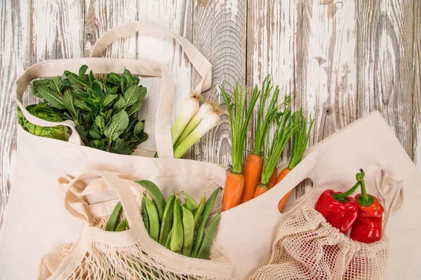 Färska grönsaker i bio eco bomull väskor på gamla träbord. Noll avfall shopping koncept. — Stockfoto