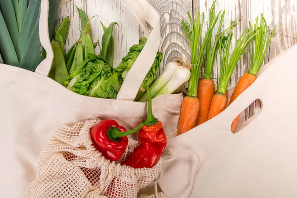 Sayuran segar dalam tas kapas bio eco di atas meja kayu tua. Konsep zero waste shopping . — Stok Foto