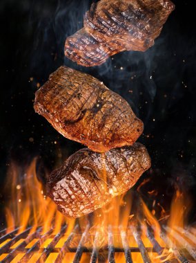 Lezzetli biftekler havada uçuşuyor demir ızgaralar ateş ateşiyle yanıyor.