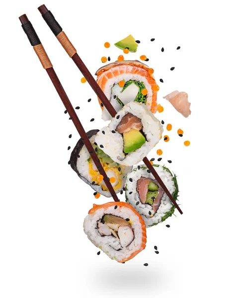 Pedaços de delicioso sushi japonês congelado no ar. — Fotografia de Stock