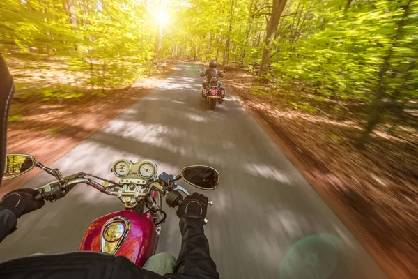 Motorradfahrerin fährt im Frühlingswald. — Stockfoto